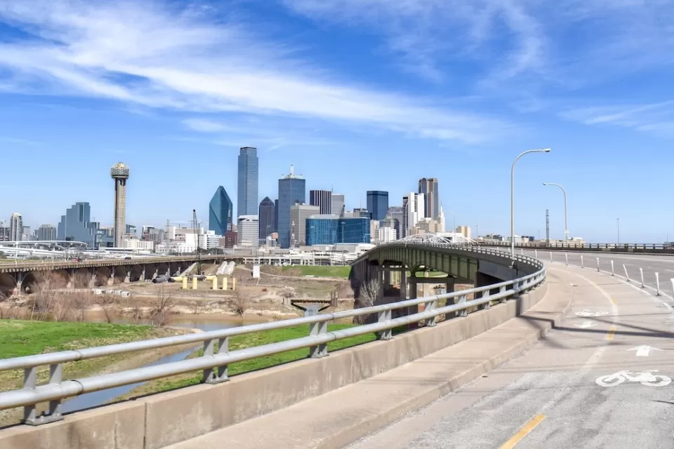 Separated protected bike lane on highway leading toward downtown Dallas, Texas.